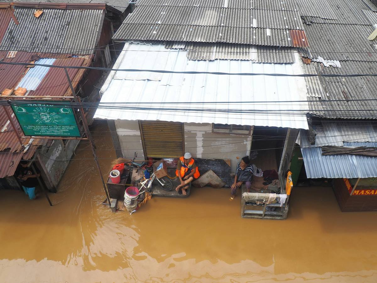 People is seen talking in front of their house while flood happen because of bad weather around Jakarta, Indonesia, March 4, 2025.